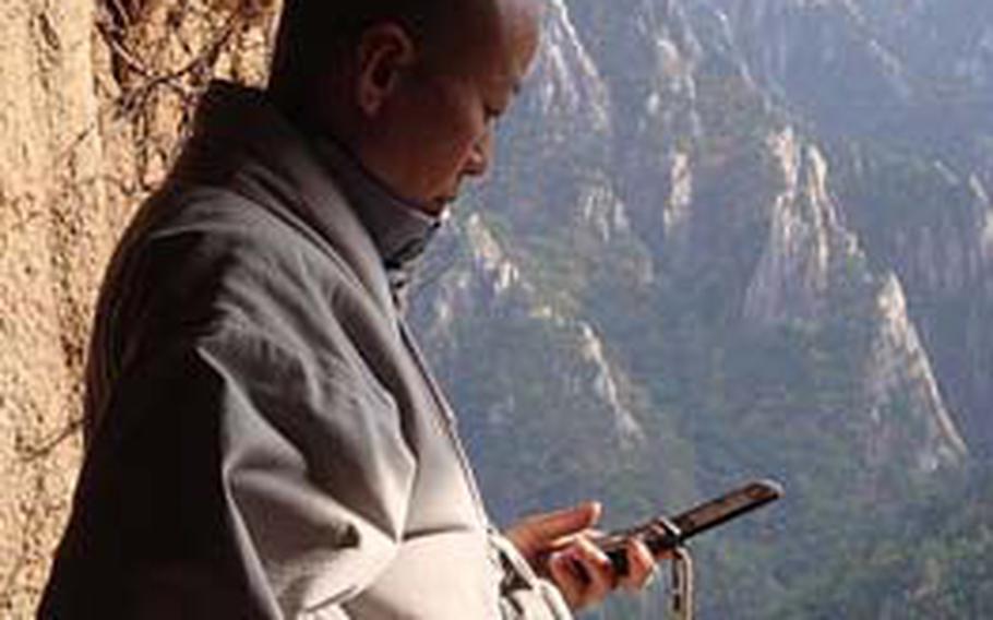 A monk checks his cell phone at the entrance to Seoraksan’s Geumganggul Cave. The steep trail to the cave, which has a small temple inside, is one of many hikes within Seoraksan National Park.