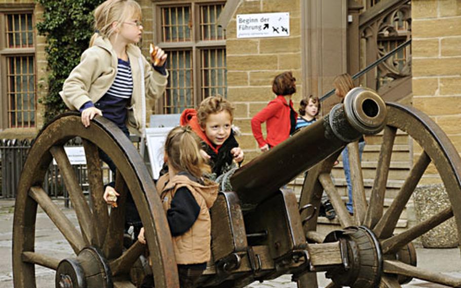 Children play on the antique cannon near the starting point of the Hohenzollern Castle tour.