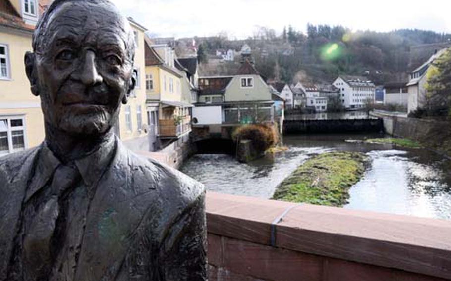 A bronze statue of author Hermann Hesse looks toward downtown Calw, Germany, from the bridge over the Nagold River.