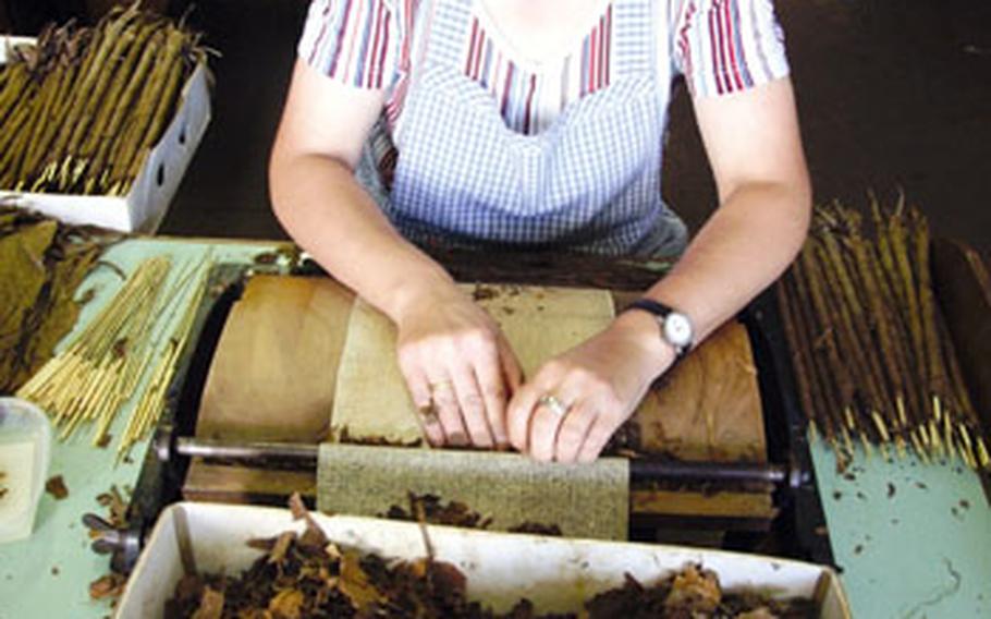 A Wolf und Ruhland employee rolls one of the 17 different types of cigars produced by the company.