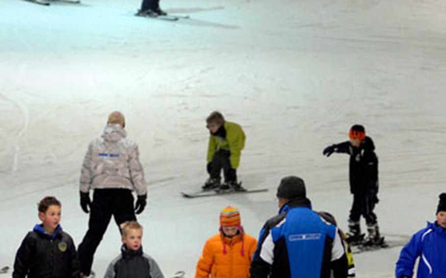 Student skiers listen to an instructor as others work their way down the 8,200 square foot kiddy piste at Snow Valley.