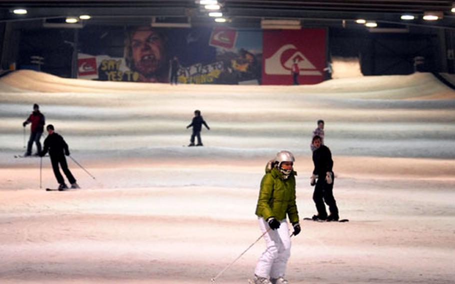 Skiers and snowboarders traverse the main ski area at Snow Valley indoor resort.