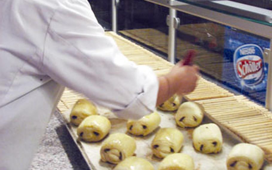 In the wee hours of the morning, Paris Boulangerie and Patisserie owner Emine Temiz adds finishing touches to the “pain au chocolat” before baking.