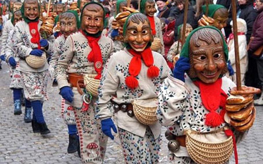 Members of a Fastnet guild march during a parade in Schramberg, Germany. Wooden masks of various shapes and expressions are typical of Black Forest carnival celebrations.