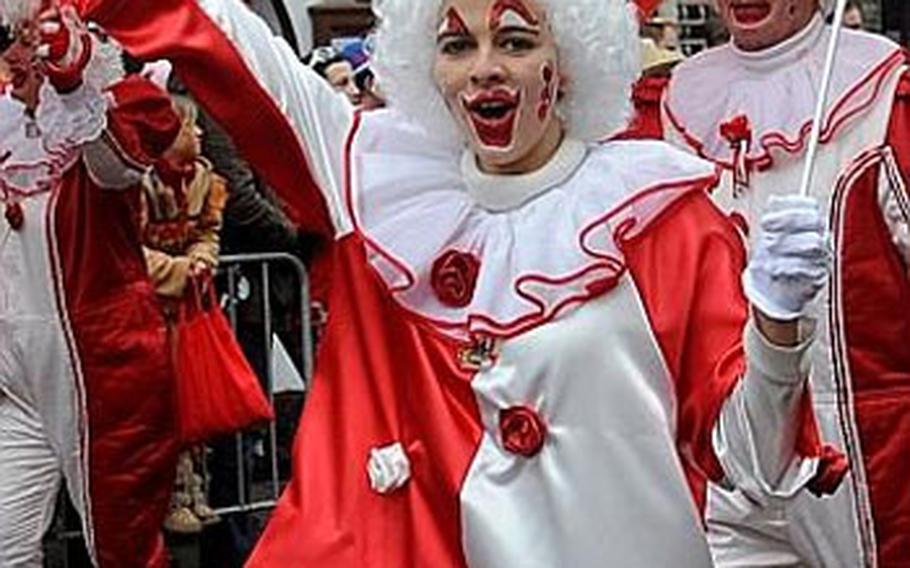 A participant in the Rose Monday Karneval parade in Düsseldorf, Germany, waves to the crowd. Clowns are a popular costume theme in the city’s festivities.