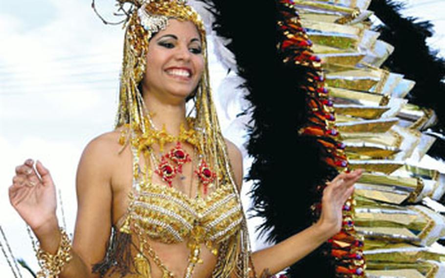 A dancer in a golden costume rides a float during the main carnival parade at Santa Cruz de Tenerife.