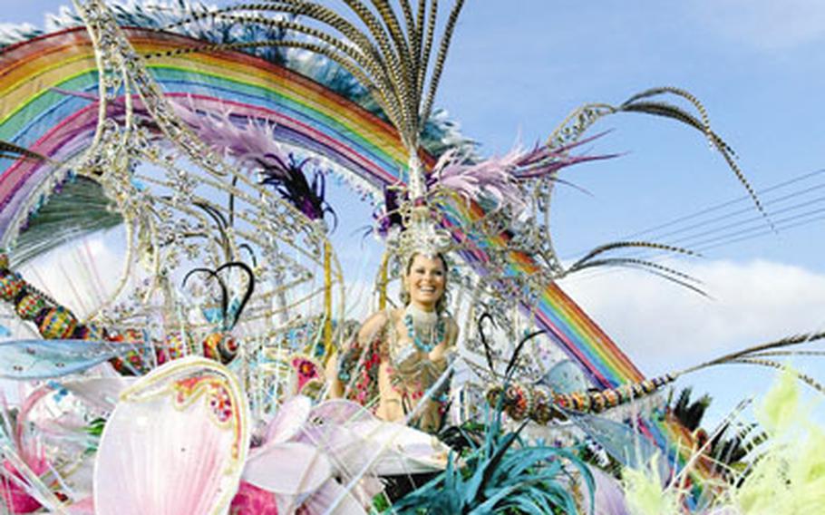 A parade participant surrounded by fabric flowers, huge feathers and an artificial rainbow rides through the streets of Santa Cruz de Tenerife during its carnival festivities.