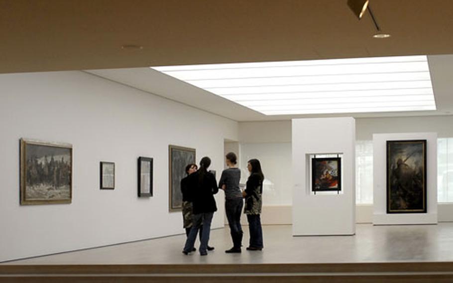 Visitors to the Kunstmuseum Stuttgart stop and admire some of the 19th- and 20th-century paintings in the museum&#39;s permanent collection.