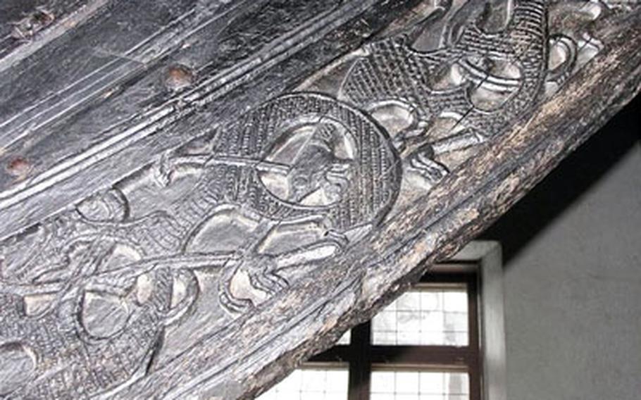 A close-up shows detailed carvings on the ship’s prow.
