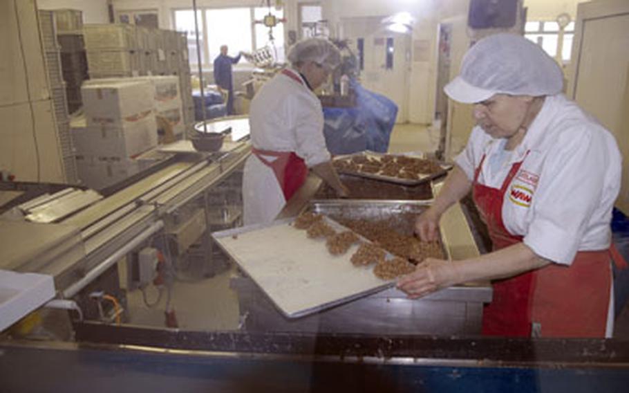 Guests can watch workers make chocolate items such as these puffed-rice treats during a window tour.