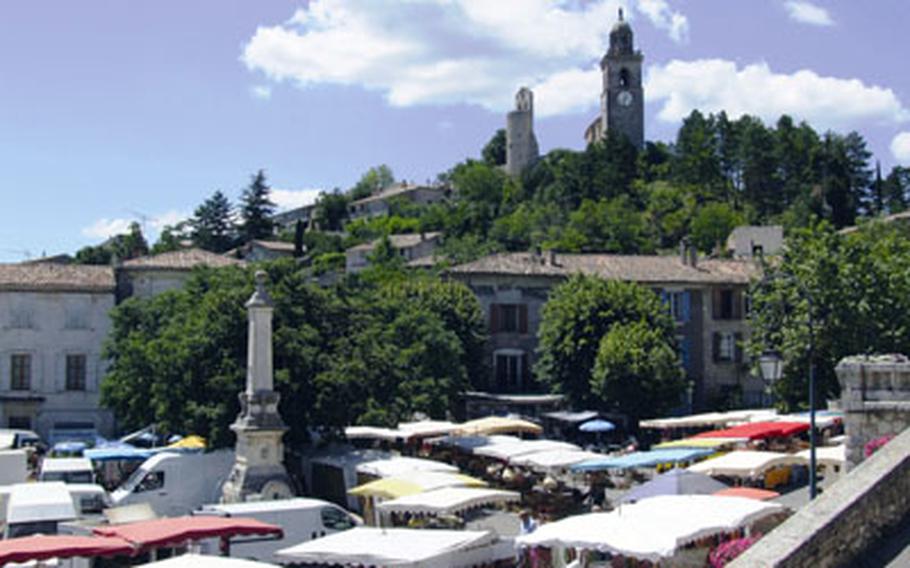 An ancient church dominates a hilltop in Reillanne, France. The Sunday market takes place in the square below.