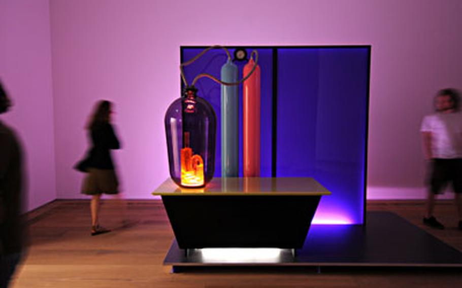 “Kandor 15” is the title of a science-fiction, dreamlike installation created by Mike Kelley with wood, Plexiglas, aluminum, glass, fluorescent lights and audio equipment.