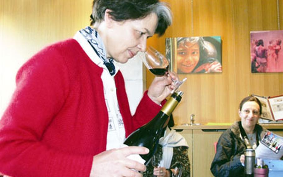 Caroline Rinaldi at Cave de Rasteau sniffs the bouquet of a Cotes de Rhone red wine during a group tasting. She said the cooperative hopes to have its red wines elevated to cru status soon.