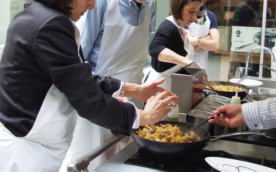 The cooking-class students - Bob is second from left - mix all the ingredients for the last step of the L'atelier des Chef class.  Decorated plates, from which the students will eat the final product, are in foreground.