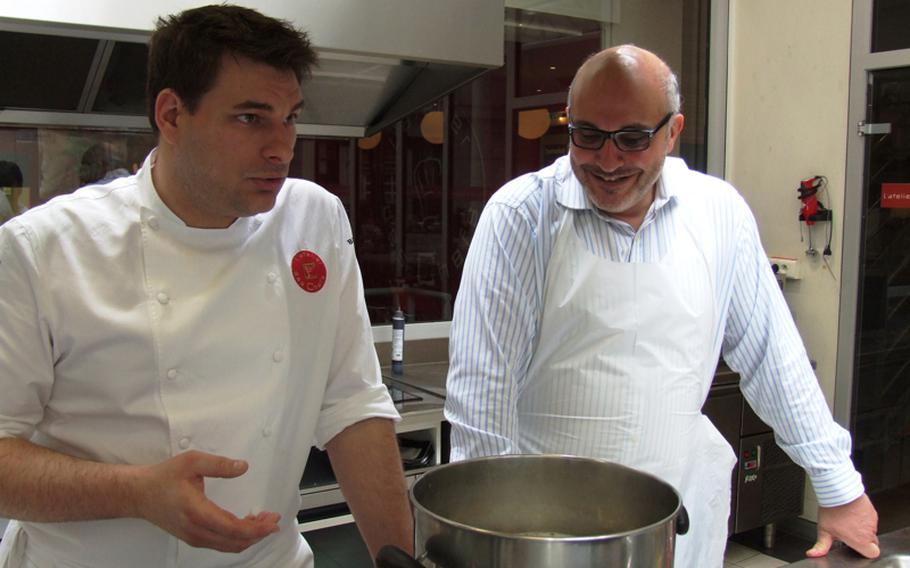 Jack Bussy, left, who attends the L'atelier des Chefs lunchtime cooking classes two to three times a week, listens as chef-instructor François Pelletier gives tips on preparing pasta for Farfalle au Canard, Citron et Câpres.