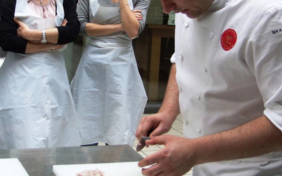Chef-instructor François Pelletier prepares to skin a duck breast during a  L'atelier des Chefs lunchtime course in Paris.