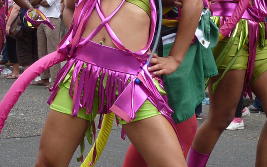 A group in costume dance and pose at London's Notting Hill Carnival.