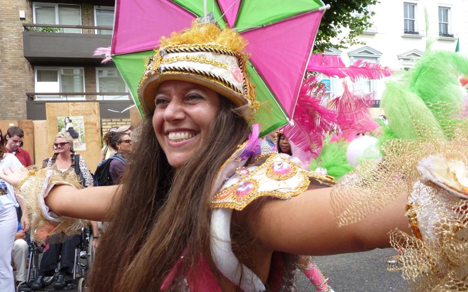 A participant in the Notting Hill Carnival parade greets spectators as she passes by on the parade route. About 50,000 people participate in the festivities that draw more than 2 million people for the two-day event.