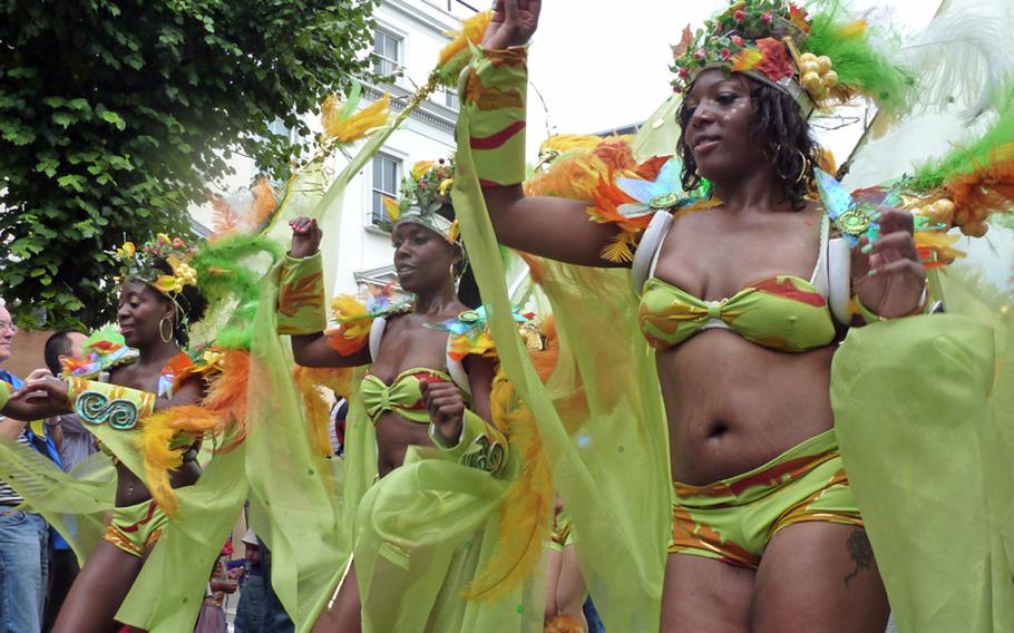 Dressed in Caribbean-inspired costumes, a group dances down the parade route during London's Notting Hill Carnival. What started as a local festival of the area's West Indian community, has grown into a big carnival, attracting more than 2 million spectators from all over the globe.