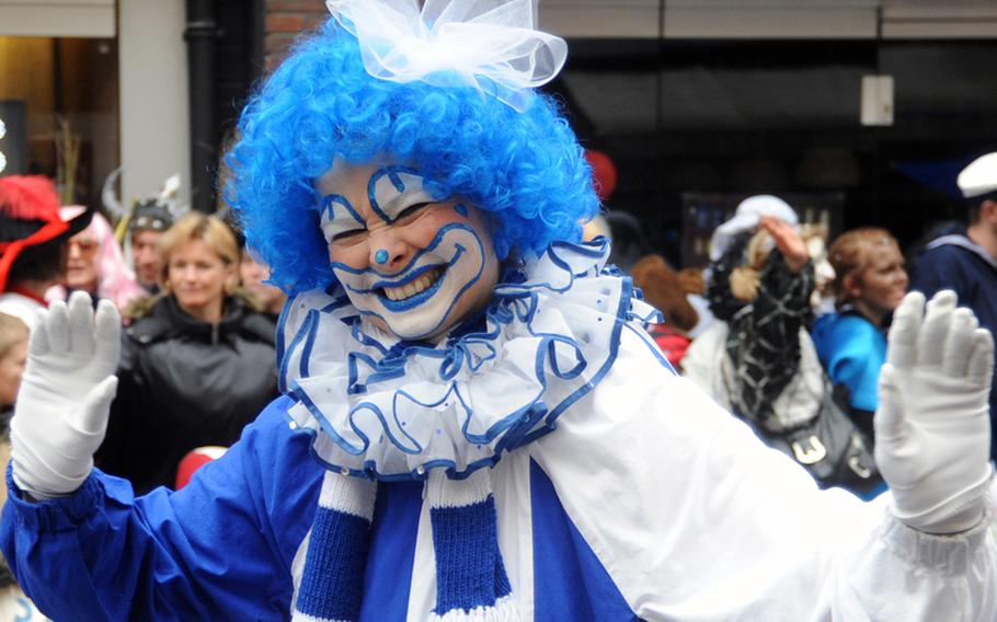 A marcher in the Düsseldorf, Germany,  Rose Monday Karneval parade waves to the crowd as she passes by. Clowns are a popular costume in D´sseldorf.