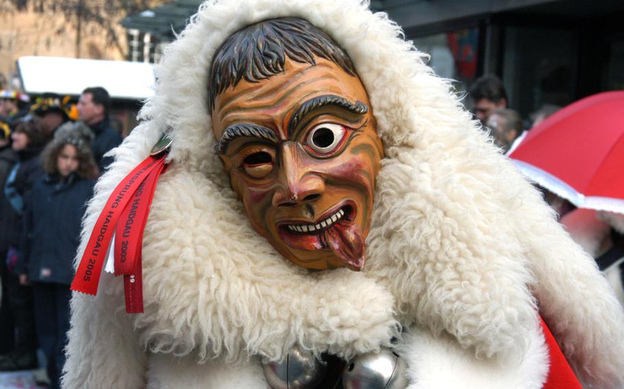 A member of a Fastnet guild marches during the Schramberg, Germany,  Fasnet parade. Wooden masks of various shapes and expressions are typical of Black Forest carnival celebrations.