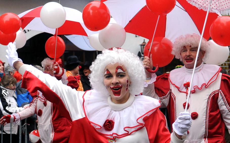 A participant in the Düsseldorf, Germany, Rose Monday Karneval parade waves to the crowd as she passes by.