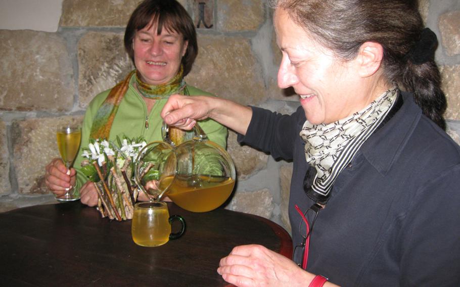 Joyce Lambert of Echterdingen, Germany, gets a fresh glass of Riesling from Gerlinde Zaiss at the Sonnenbesen. The winemakers often serve the wine via pitchers filled from a large cask.