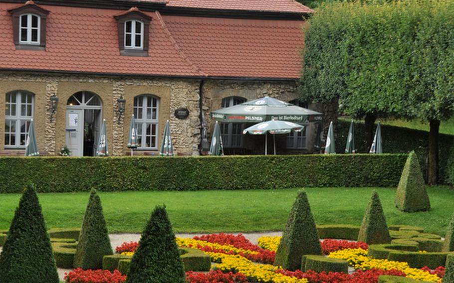 The front lawn of the Oriental House in Sanspareil, Germany. On the far end of the lawn sits Castle Zwernitz&#39;s former kitchen, which is now a beer garden and restaurant for visitors of the historic Rock Garden. One of the castle towers looms in background.