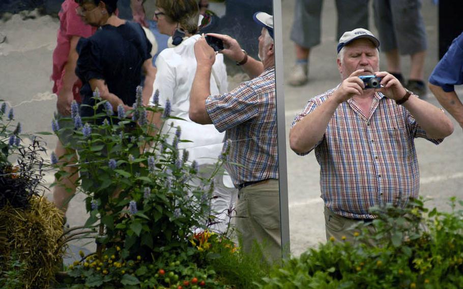 A visitor snaps photos of some of the vegetation on display at this year&#39;s federal horticulture show in Koblenz, Germany.  The exhibition takes place in at three sites in the city and covers a total of 119 acres.