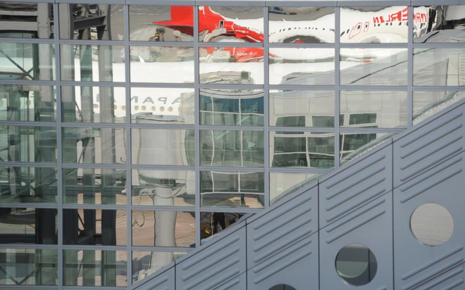 Jets from Air Berlin and Japan Airlines are reflected in the window of Frankfurt Airport&#39;s Terminal 2.