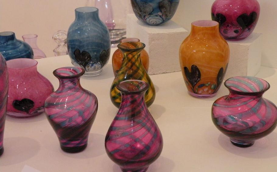 The Tartan Twist, foreground, and Cadenza vases (background) are among nearly 400 pieces of glass on display at the arts center until Feb. 25, 2012.