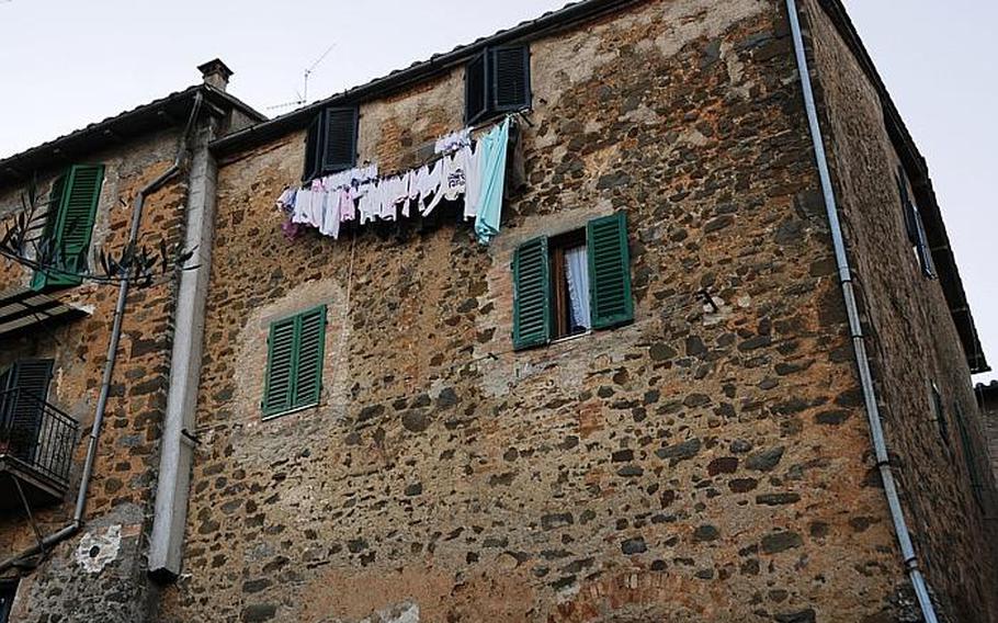 Laundry dries in a cold winter day from windows of one of the many stone homes characteristic of Montalcino, in Tuscany.