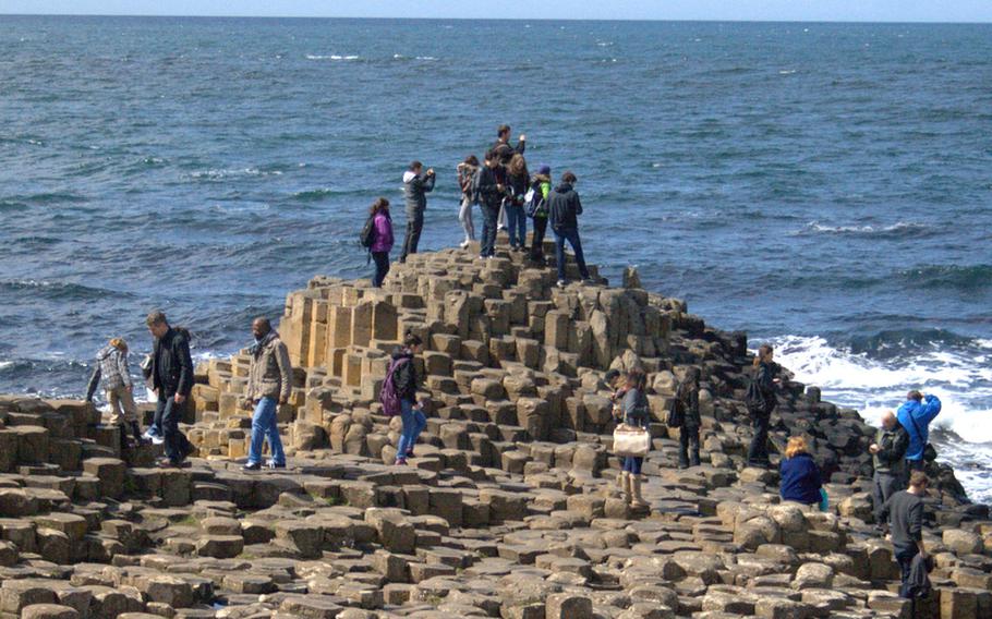 Tourists clamber over and across the 40,000 polygonal stones of the Giants Causway in Ireland.