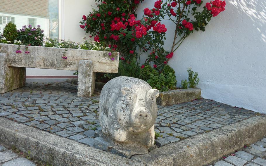 A pig statue sits on a small square in the colorful little town of Wemding, Germany.