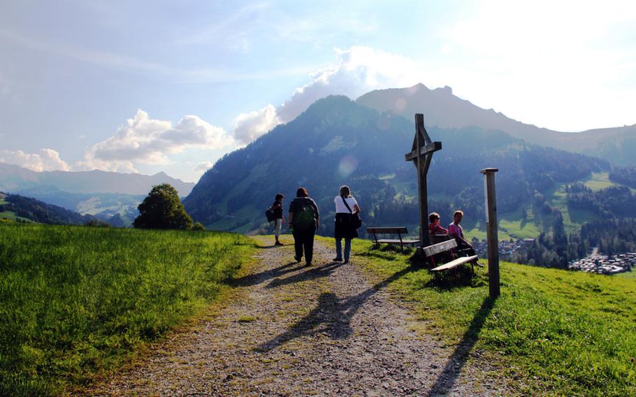Hikers stroll by a couple who has a picture-perfect view of the landscape along one of Switzerland's many hiking trails.