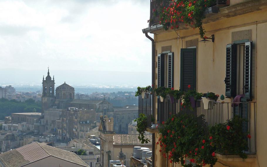 A view across Caltagirone from the Staircase of Santa Maria del Monte. The staircase is lined by houses, many with flower-bedecked balconies, like the ones at right.