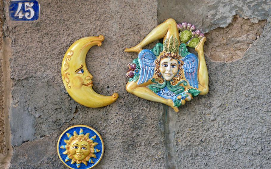 These colorful pieces of pottery seen hanging on a wall in Caltagirone are typical souvenirs of Sicily.