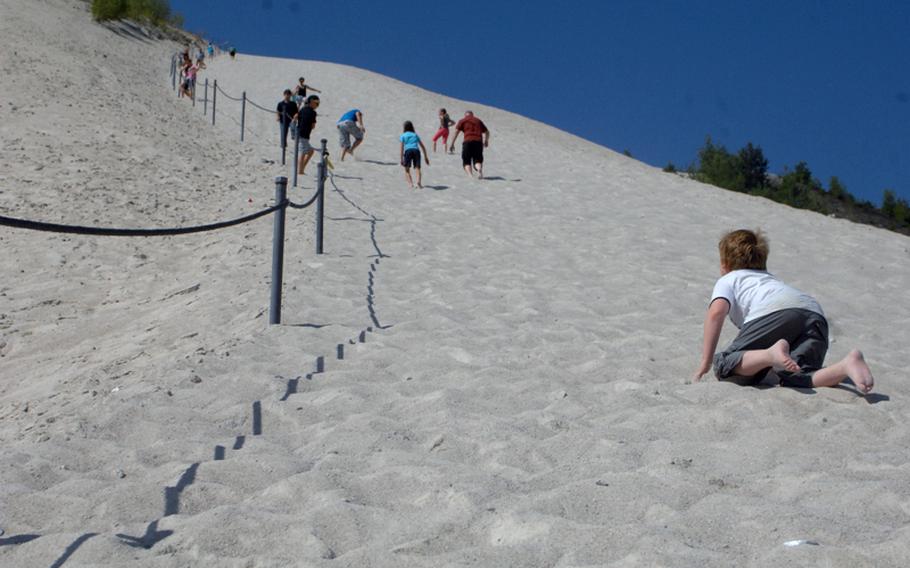 A young visitor at Monte Kaolino amusement park in Hirschau, Germany, struggles to climb the massive sand hill at the center of the park. Left over from decades of quartz and kaolin mining, the nearly 4 00-foot tall sand hill rewards those who persevere up its slopes with a broad view of the region.