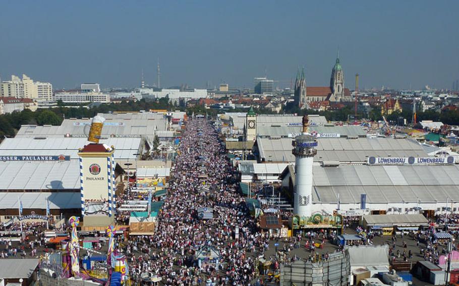 A view of the crowd and the giant Oktoberfest tents with the Munich skyline in the background, as seen from the festival's Ferris wheel.