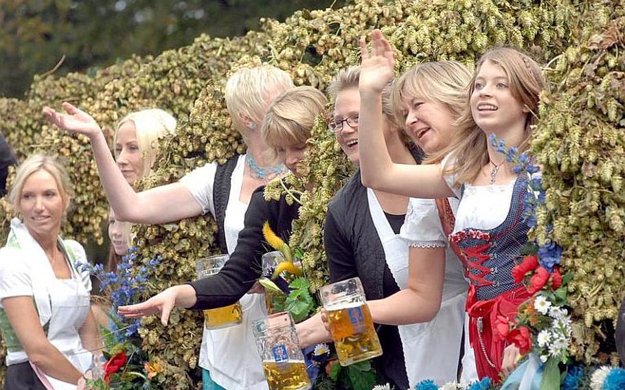 Participants in the parade of landlords and breweries wave to spectators from their floats.