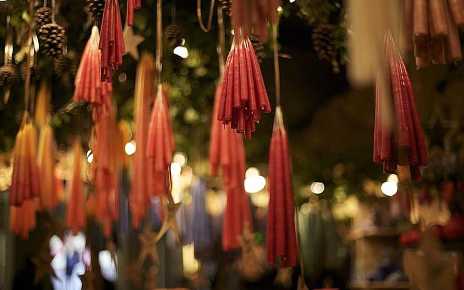 Handmade candles hang in a shop stall.