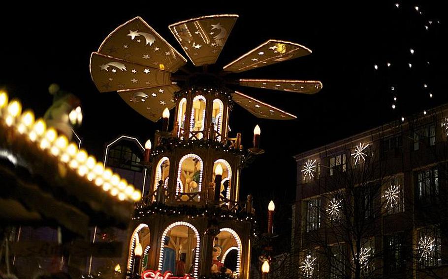 A Christmas pyramid featuring wooden toys the size of small men towers in a corner of Bonn's Christmas market.