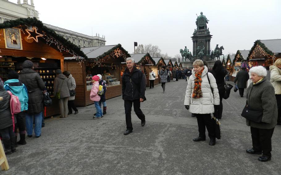 A stately monument to the 18th century Austrian ruler Empress Maria Theresa, seen in the background, reigns over the Christmas Village market at Maria-Theresian-Platz in Vienna. The market is nestled between two of the city's most famous museums, the Art History Museum, seen partially on the left, and the Museum of Natural History.