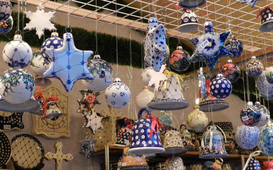 Polish pottery decorations in traditional as well as new patterns hang from a vendor's stand at a market in Vienna, Austria.