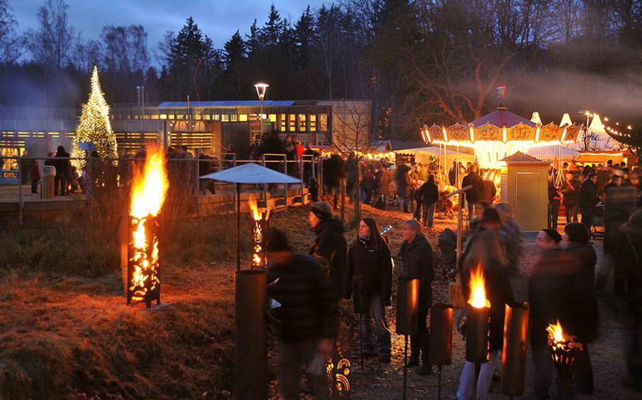 Bonfires and torches provide most of the lighting at the Johanniskreuz Romantische Waldweihnacht near Kaiserslautern, Germany. The Christmas market, sponsored by the House of Sustainability, seen in the background, is an environmentally friendly holiday market in the forest. Dates this year are Dec. 15-16.