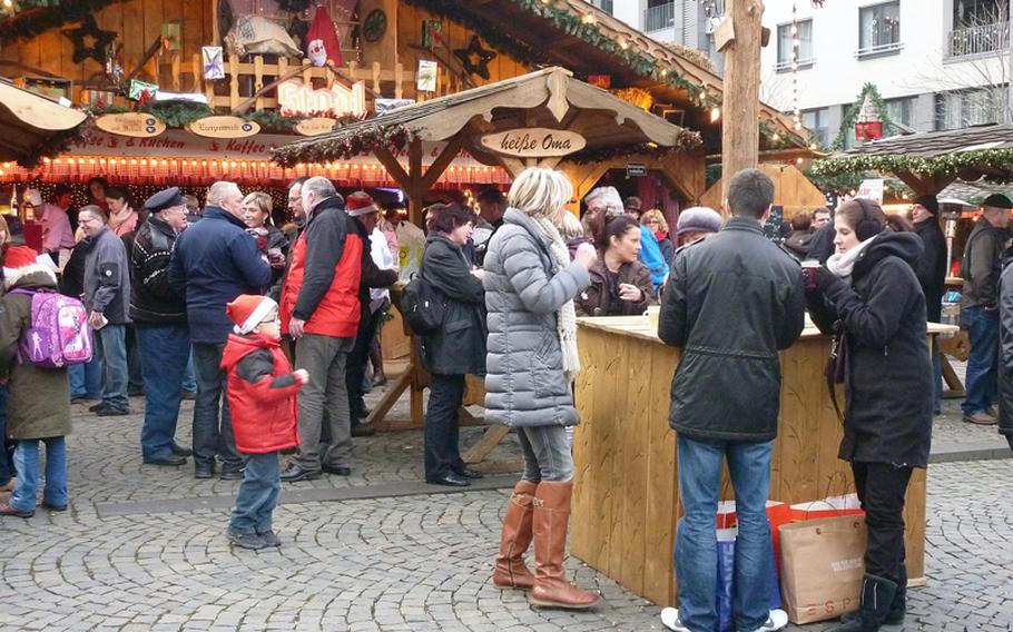 Visitors enjoy food and drinks on the Münzplatz in Koblenz, Germany, during the city's Christmas market.