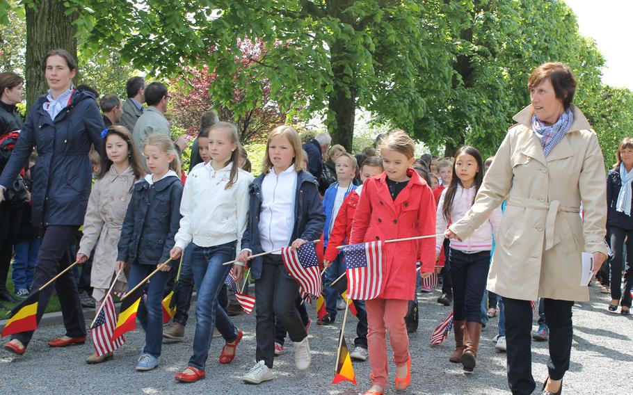 Waregem, Belgium, schoolchildren join the parade entering the Flanders Field American Cemetery. They sang "The Star-Spangled Banner" during the Memorial Day service.