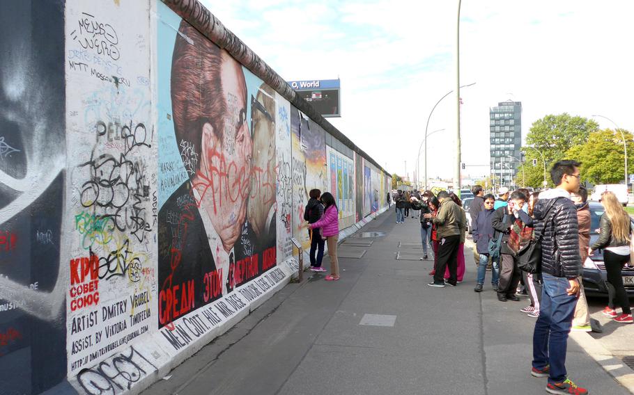 Tourists at the East Side Gallery are photographed in front of artist Dimitri Vrubel's mural of former Soviet leader Leonid Brezhnev and East Germany's Communist Party leader Erich Honecker kissing. The work is based on a photo by French photographer Regis Bossu, who also spent time as a Stars and Stripes photographer.