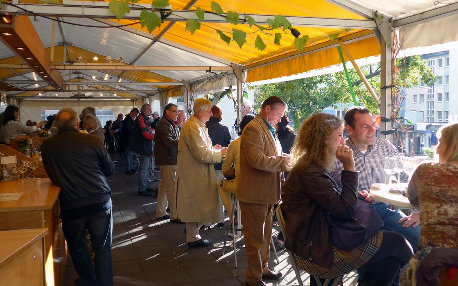 On the balcony of the Kleinmarkthalle in Frankfurt, Germany, a vintner sells wine, by the glass and by the bottle. In winter the balcony is enclosed and heated.