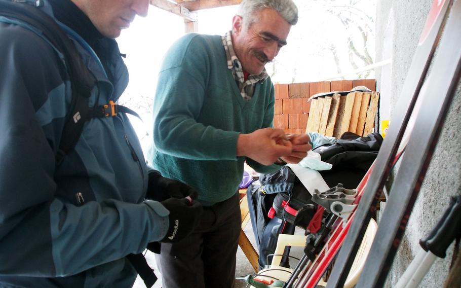Kol Gjoni, right, helps with an emergency ski repair in Valbona, Albania.